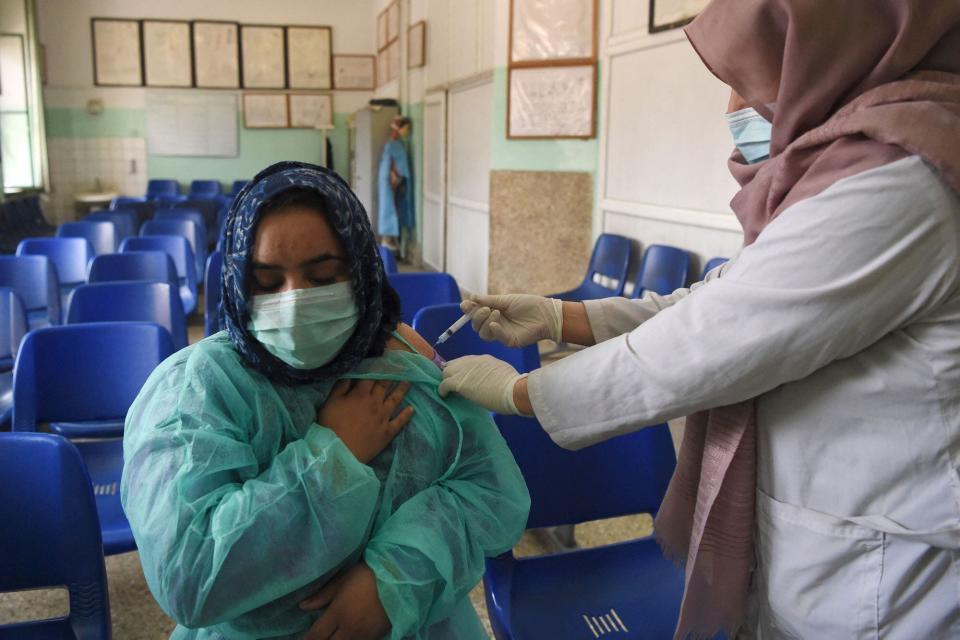 AFGHANISTAN: Un trabajador de la salud vacuna a un colega con una vacuna contra el coronavirus Covid-19 en el hospital Wazir Akbar Khan en Kabul el 2 de marzo de 2021.