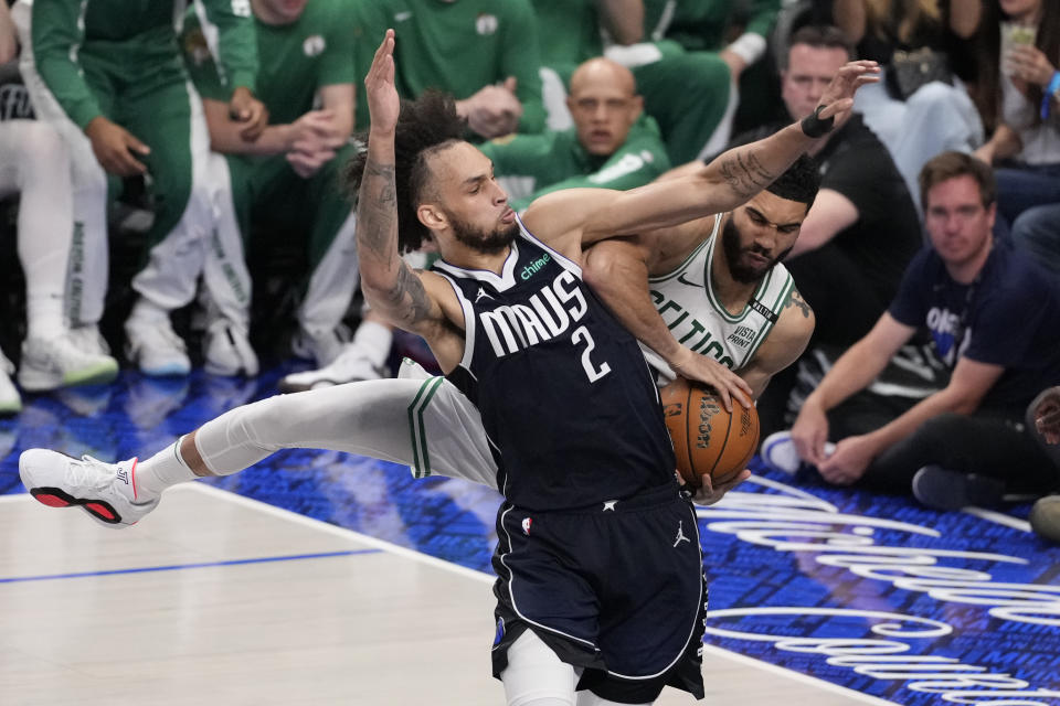 Dallas Mavericks center Dereck Lively II (2) and Boston Celtics forward Jayson Tatum (0) vie for a rebound during the second half in Game 4 of the NBA basketball finals, Friday, June 14, 2024, in Dallas. (AP Photo/Julio Cortez)