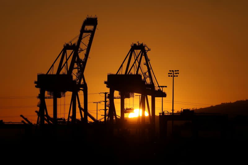 FILE PHOTO: The sun sets behind container cranes at the Port of Los Angeles, California