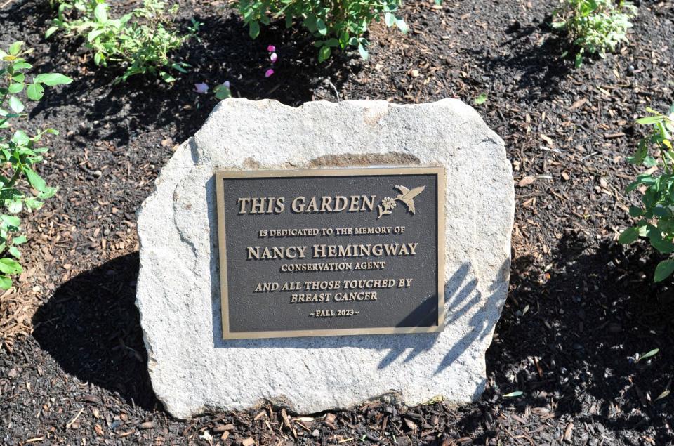 A plaque dedicates a garden in memory of the town's late conservation agent Nancy Hemingway, who died of breast cancer.