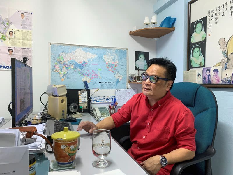 Kelvin Pang, a Singapore-based electronics broker, talks to a visitor in his office in Singapore