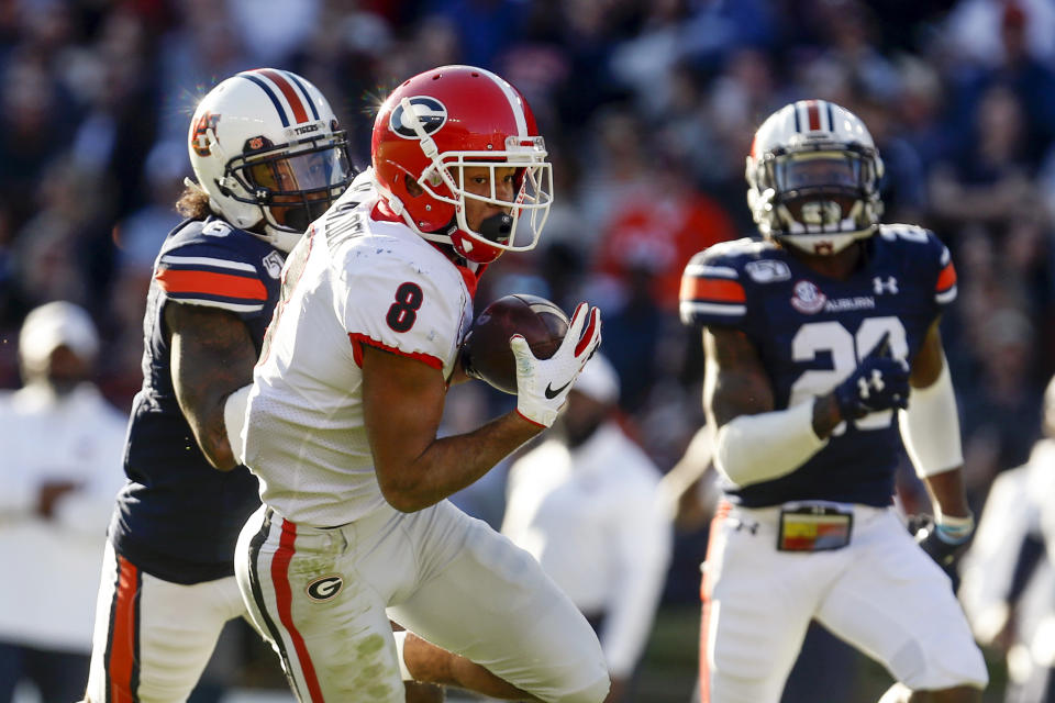 Georgia wide receiver Dominick Blaylock (8) catches a pass for a touchdown as Auburn defensive back Christian Tutt (6) defends during the first half of an NCAA college football game, Saturday, Nov. 16, 2019, in Auburn, Ala. (AP Photo/Butch Dill)