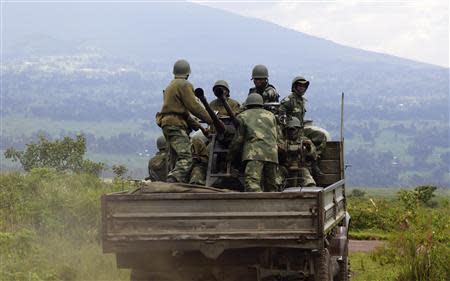 Congolese armed forces (FARDC) soldiers stand on the back of a truck as they advance to a new position while battling M23 rebels in Kibumba, north of Goma October 26, 2013. REUTERS/Kenny Katombe