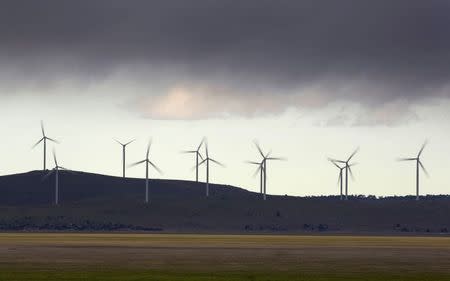 Low rain clouds pass over wind turbines operating near Tarago, north of Australia's capital, Canberra, in this July 9, 2014 file photo. REUTERS/Jason Reed/Files