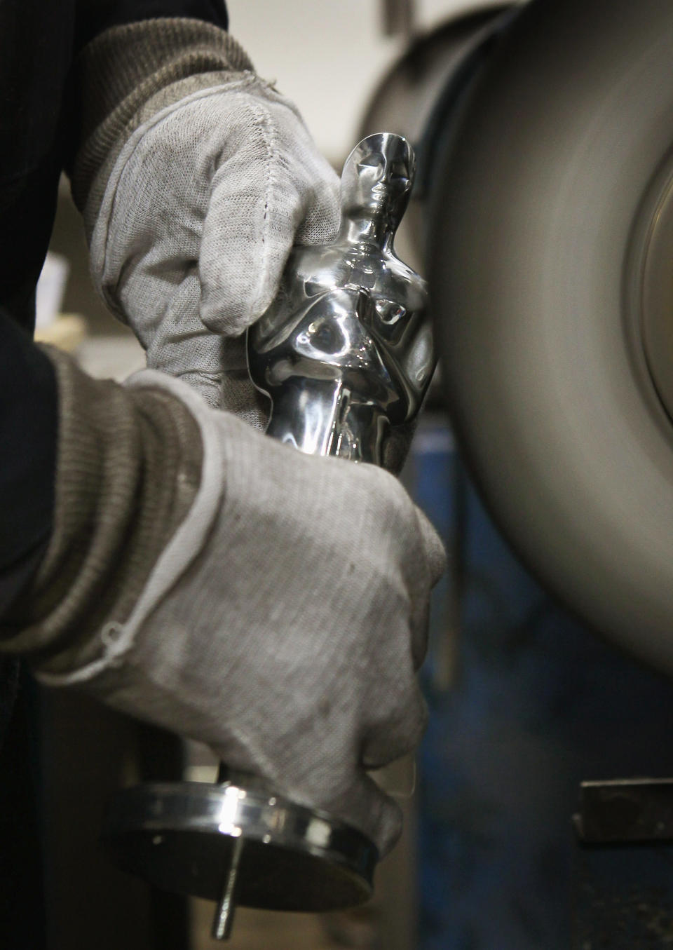 CHICAGO, IL - FEBRUARY 09: A worker polishes an Oscar statuette at R.S. Owens & Company February 9, 2012 in Chicago, Illinois. R.S. Owens manufactures the Oscar statuettes which are presented at the annual Academy Awards by the Academy of Motion Picture Arts and Sciences. After the theft of the statuettes prior to the 2000 Academy Awards the company began casting the statuettes one year in advance of the show. (Photo by Scott Olson/Getty Images)