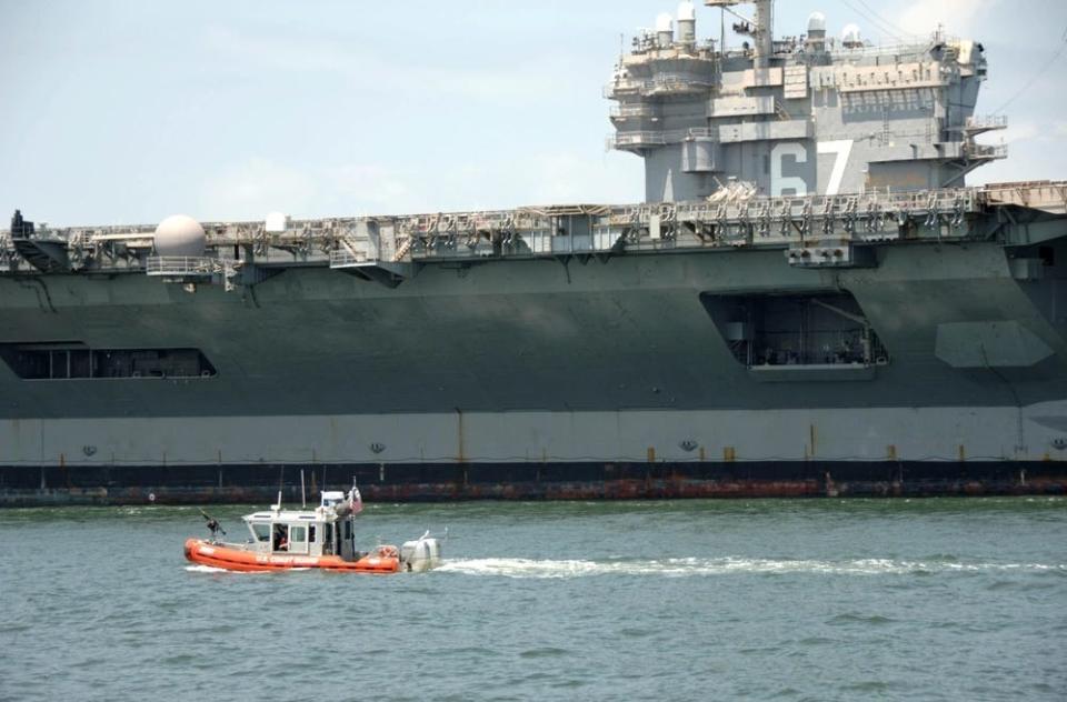 A safe boat maintains a security zone around the USS John F. Kennedy