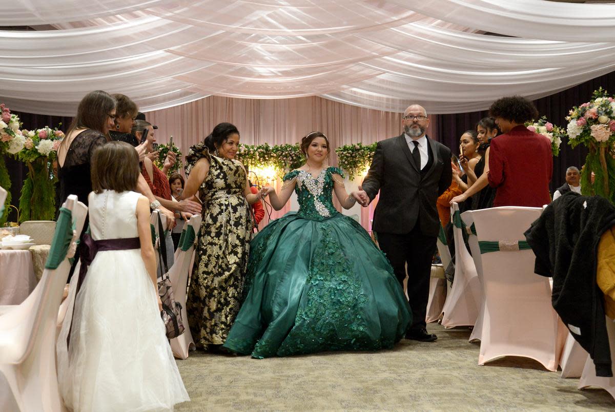Guest stand and applaud as Sienna Raley, flanked by her parents Maria and Troy, begins the Grand Entrance at her Quincenera Saturday, December 16, 2023, in Didoll, Texas.