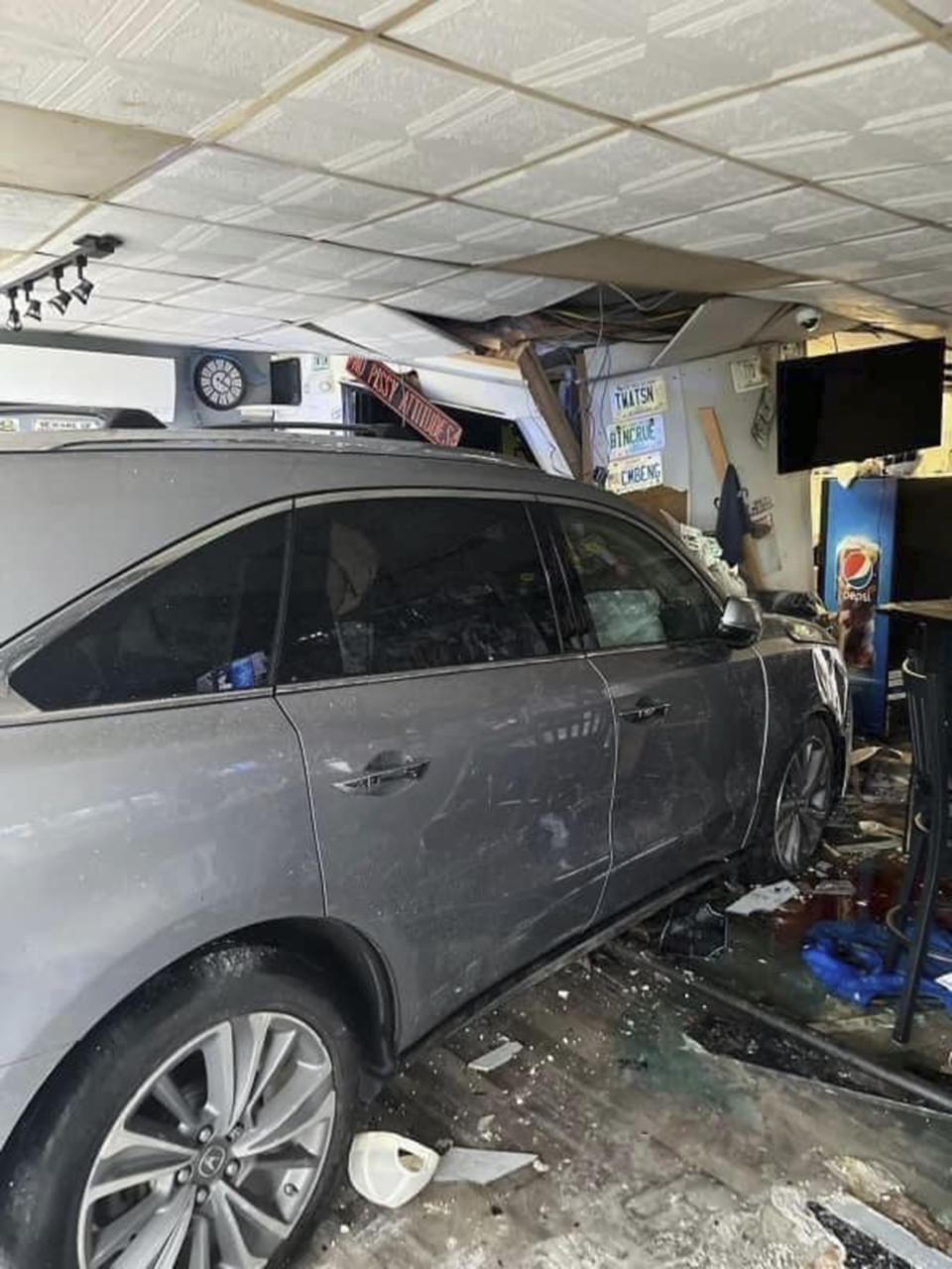 In this photo released by the Laconia Fire Department, a vehicle sits inside a restaurant after crashing through the wall on Sunday, July 2, 2023, in Laconia, NH. The car struck the busy Looney Bin Bar & Grill and injured more than a dozen patrons inside, authorities said. (Laconia Fire Department via AP)