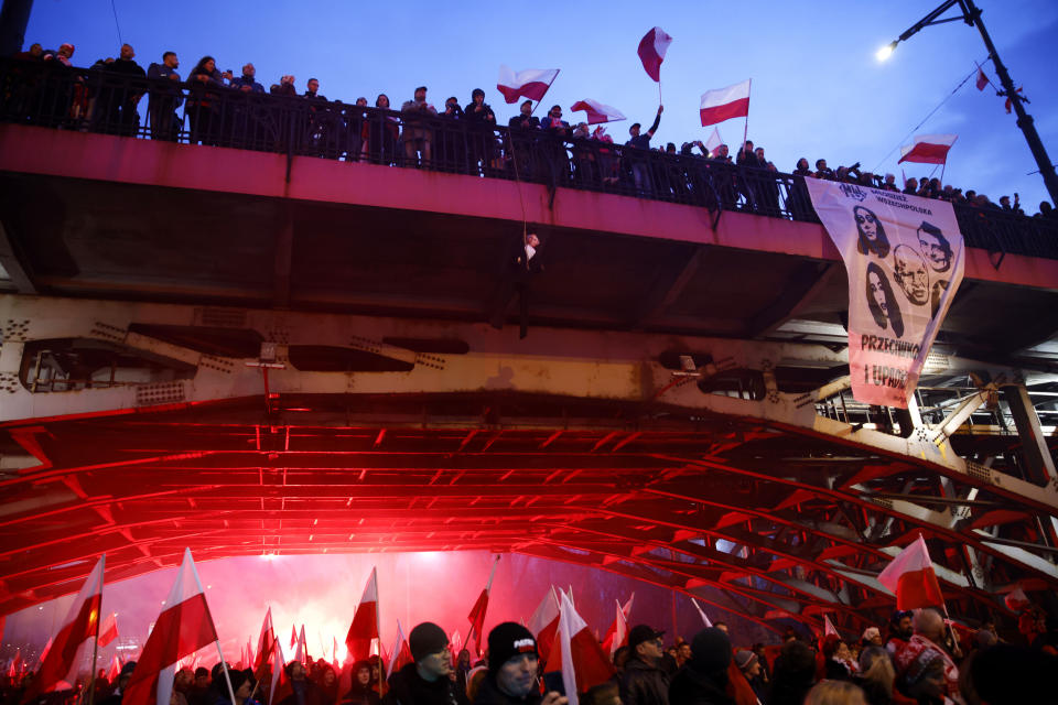 People stand on a bridge as thousands of people have gathered in the city center for a yearly Independence Day march organized by nationalist groups that has been marked by violence in past years in Warsaw, Poland, Friday, Nov. 11, 2022. (AP Photo/Michal Dyjuk)