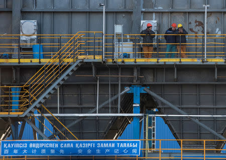 Workers look on during an opening ceremony of the cement plant built jointly by Chinese Gezhouba Group and Kazakh firm Corporation DANAKE on the outskirts of the village of Shieli, southern Kazakhstan December 11, 2018. REUTERS/Mariya Gordeyeva