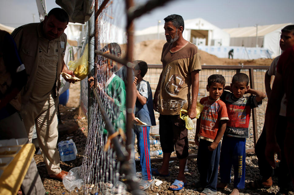 Displaced Iraqis wait for food supplies near Mosul