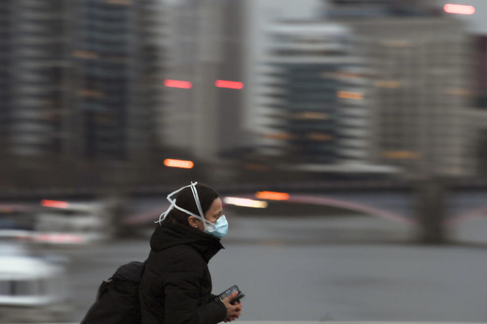 A member of the public walks on an empty Westminster Bridge wearing a protective mask, due to the Coronavirus outbreak in London, Wednesday, April 1, 2020. The new coronavirus causes mild or moderate symptoms for most people, but for some, especially older adults and people with existing health problems, it can cause more severe illness or death.(AP Photo/Alberto Pezzali)