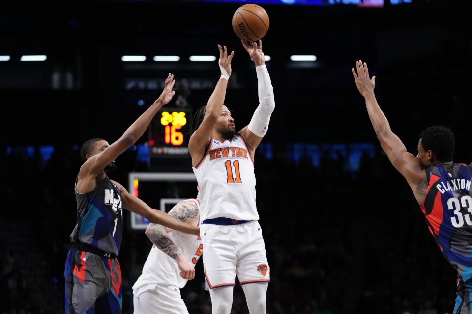 New York Knicks' Jalen Brunson (11) shoots over Brooklyn Nets' Nic Claxton (33) and Mikal Bridges (1) during the first half of an NBA basketball game Wednesday, Dec. 20, 2023, in New York. (AP Photo/Frank Franklin II)