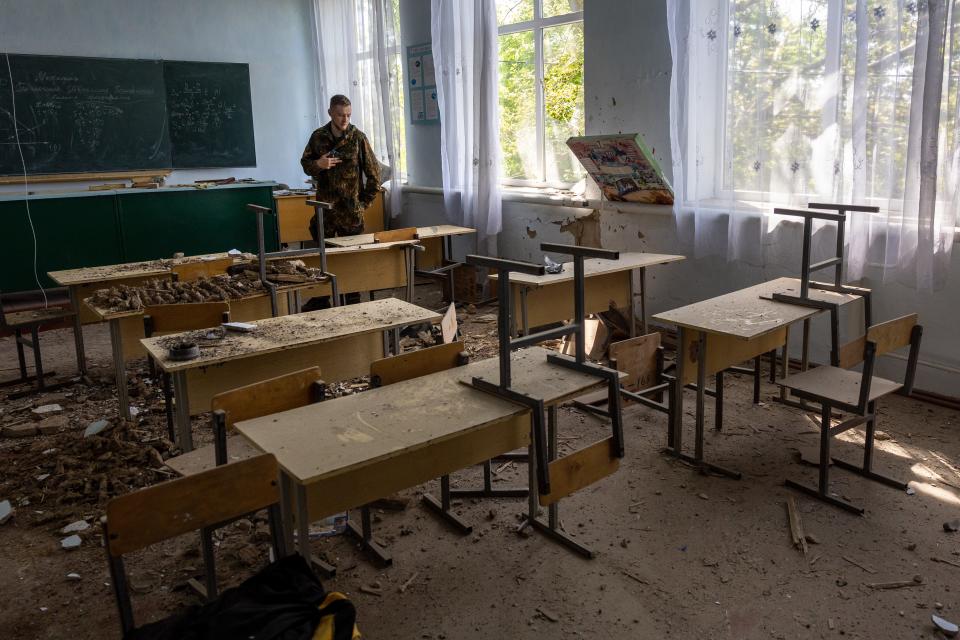 A soldier inspects a damaged classroom in a school on Sunday in Kochubeivka, Ukraine. Kherson Oblast fell to Russia shortly after the Feb. 24 invasion, as Russia sought to create an overland corridor from Crimea to separatist-held areas in the east. Most of Kherson Oblast remains Russian-occupied.
