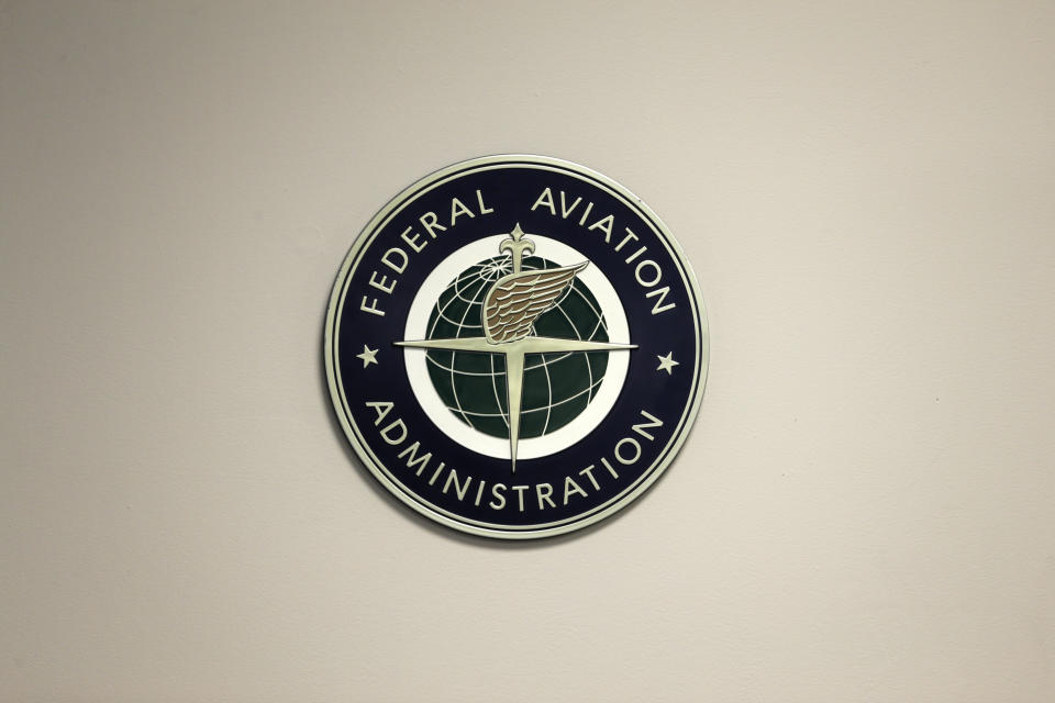 FILE - A Federal Aviation Administration sign hangs in the tower at John F. Kennedy International Airport in New York, March 16, 2017. Officials are investigating a close call at the New York airport that happened Friday, Jan. 13, 2023, between a plane that was crossing a runway and another that was preparing for takeoff. The FAA said Saturday, Jan. 14, that it will investigate the incident, which happened around 8:45 p.m. (AP Photo/Seth Wenig, File)