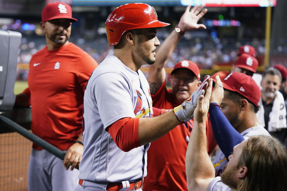 St. Louis Cardinals' Nolan Arenado, front left, celebrates after his home run against the Arizona Diamondbacks with coaches and teammates, including Taylor Motter, right, Joe McEwing, center, and Oliver Marmol, back left, during the fifth inning of a baseball game Monday, July 24, 2023, in Phoenix. (AP Photo/Ross D. Franklin)