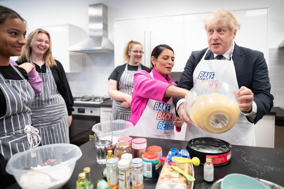 Mr Johnson was aided by Ms Patel as he made the cake (Stefan Rousseau/PA) (PA Wire)