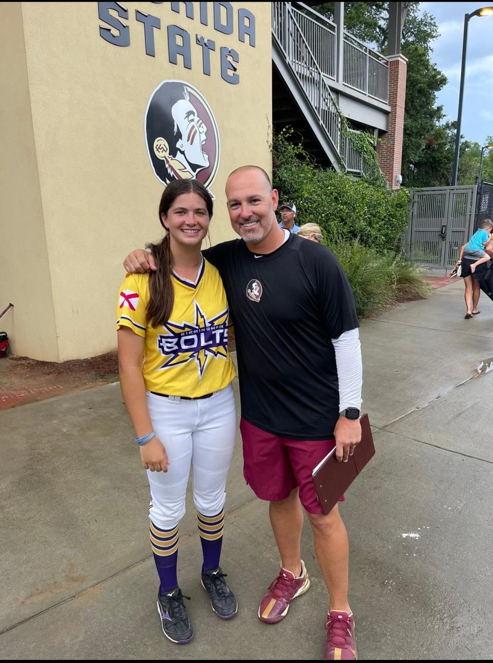 Kaylee Goodpaster takes a picture with Florida State assistant softball coach Troy Cameron during a softball camp earlier this summer.