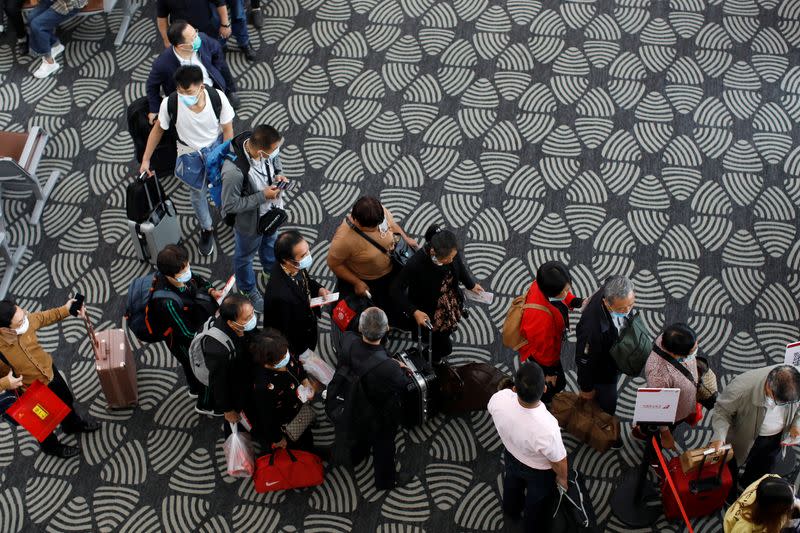 Passengers wearing face masks following the coronavirus disease (COVID-19) outbreak line up with luggages at the Beijing Daxing International Airport, ahead of Chinese National Day holiday, in Beijing