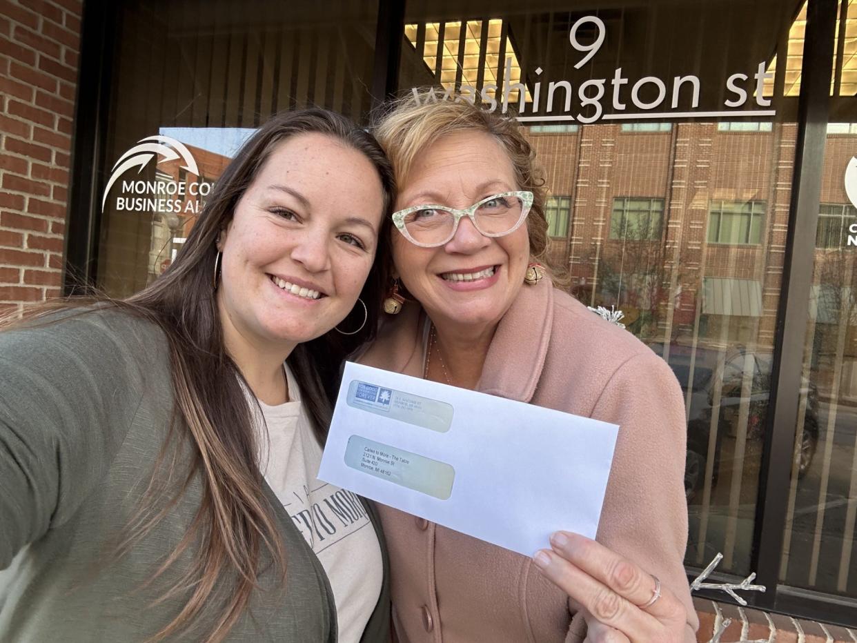 Tilly Grace (left) and Libbie Hall are shown with a grant check from the City of Monroe. Monetary donations and food donations are needed to support The Table.