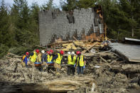 Rescue workers remove a body from the wreckage of homes destroyed by Saturday's mudslide near Oso, Wash, on Monday, March 24, 2014. The search for survivors of Saturday's deadly mudslide grew Monday to include scores of people who were still unaccounted for as the death toll from the wall of trees, rocks and debris that swept through the rural community rose to at least 14. (AP Photo/seattlepi.com, Joshua Trujillo)