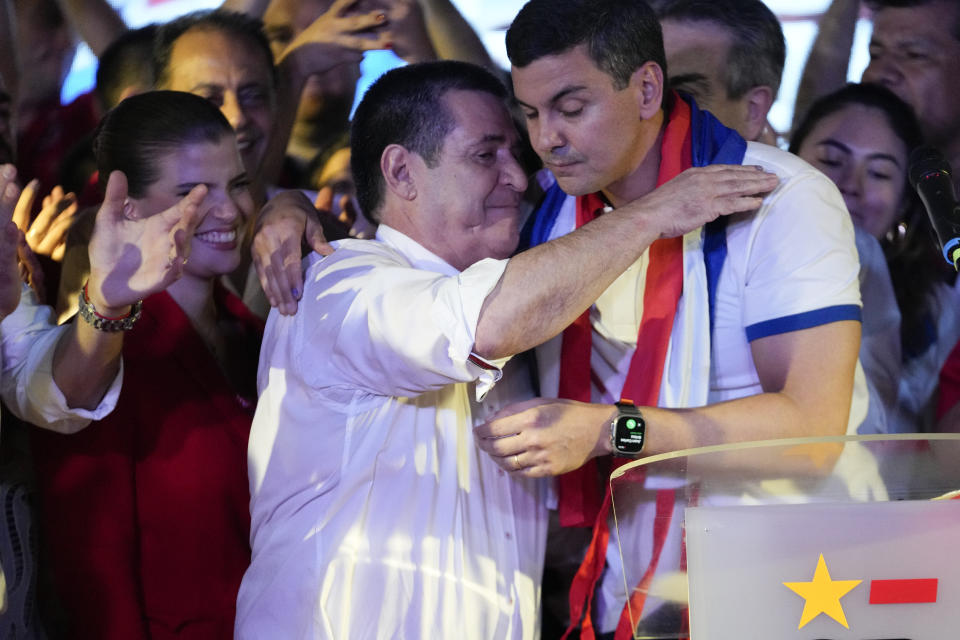 Santiago Penñ, presidential candidate of the Colorado ruling party, right, embraces former President Horacio Cartes after the voting closed during general elections in Asuncion, Paraguay, Sunday, April 30, 2023. (AP Photo/Jorge Saenz)