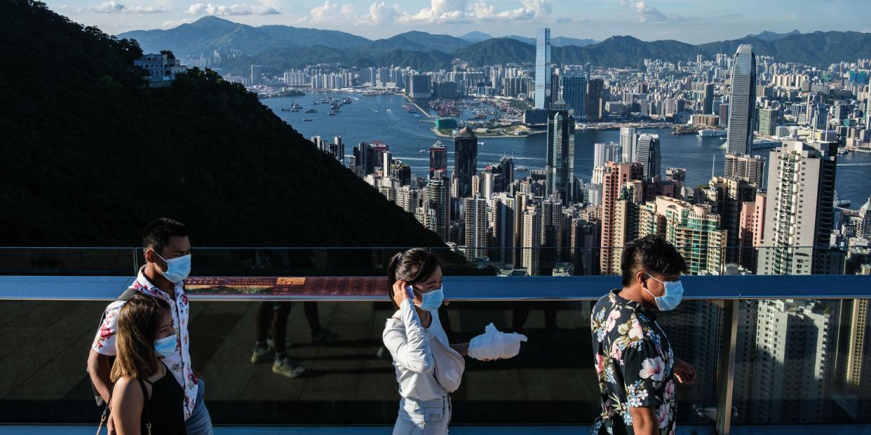 Visitors walk along a viewing platform on Victoria Peak in Hong Kong on July 28, 2020. (Photo by ANTHONY WALLACE / AFP) (Photo by ANTHONY WALLACE/AFP via Getty Images)