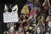 A cutout of Bucky, the Wisconsin mascot, holds a sign during the second half of an NCAA college basketball game between Wisconsin and Michigan Sunday, Feb. 14, 2021, in Madison, Wis. (AP Photo/Morry Gash)