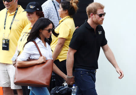 El príncipe Enrique de Reino Unido (a la derecha) y su novia, la actriz Meghan Markle, llegan un partido de tenis en silla de ruedas durante un evento de los Juegos Invictus en Toronto, Ontario, Canadá. 25 de septiembre, 2017. REUTERS/Mark Blinch