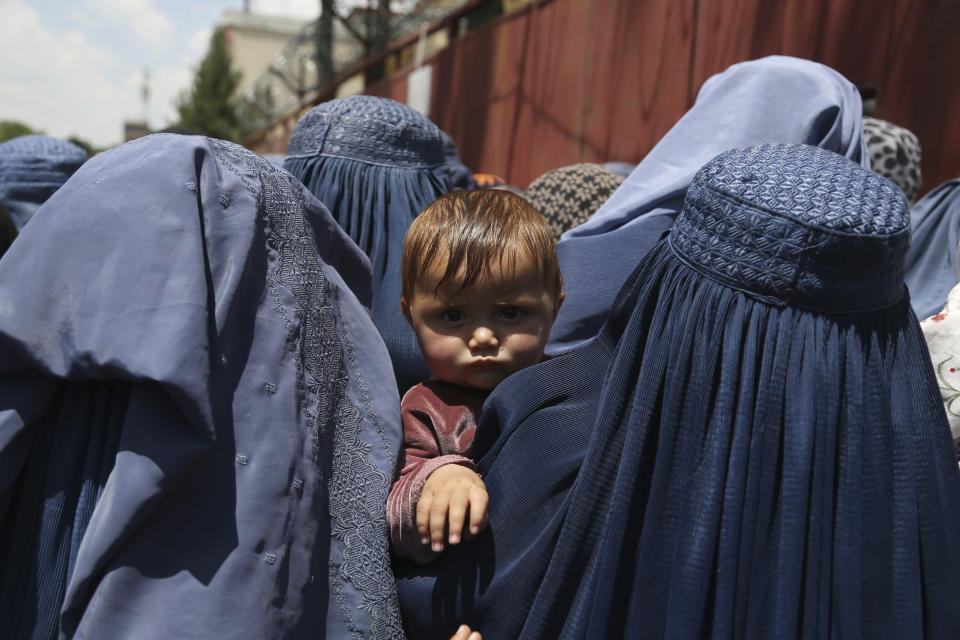 FILE - In this June 3, 2019 file photo, Afghan women wait to receive free food donated by Muslim Hands, a not-for-profit organization, in Kabul, Afghanistan. After nearly 20 years since the ouster of the Taliban and hundreds of millions of dollars spent on infrastructure and aid, many Afghan women still have poor access to health facilities and providers, Human Rights Watch said Thursday, May 6, 2021 in its latest report. The rights group said that even basic information on health and family planning is not available to most Afghan women. (AP Photo/Rahmat Gul, File)