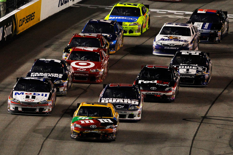 RICHMOND, VA - APRIL 28: Kyle Busch, driver of the #18 M&M's Ms. Brown Toyota, takes the lead over Tony Stewart, driver of the #14 Mobil 1/Office Depot Chevrolet, on a late restart during the NASCAR Sprint Cup Series Capital City 400 at Richmond International Raceway on April 28, 2012 in Richmond, Virginia. (Photo by Todd Warshaw/Getty Images for NASCAR)