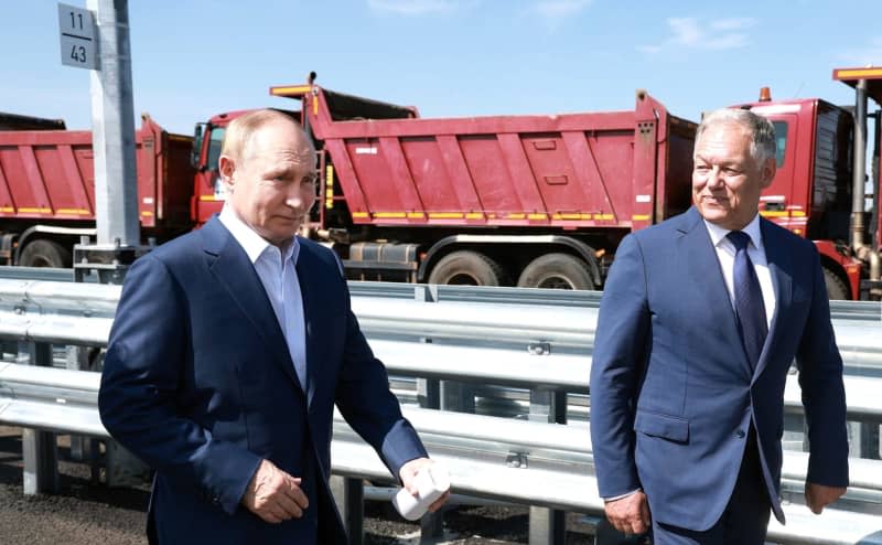 Russian President Vladimir Putin (L) and Russian Deputy Prime Minister Marat Khusnulin react during the opening ceremony of the last phase of the Moscow-St. Petersburg highway.  -/Kremlin/dpa