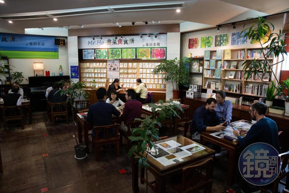 禾園茶館沒有過多華麗裝潢，木質空間以大面積書牆、彩繪明信片與綠色植栽妝點。