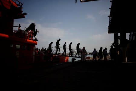 Migrants, who are part of a group intercepted aboard a dinghy off the coast in the Mediterranean sea, walk along a gangway after arriving on a rescue boat at a port in Malaga, southern Spain October 13, 2017. REUTERS/Jon Nazca