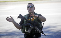 <p>A law enforcement officer tells anxious family members to move back, Wednesday, Feb. 14, 2018, in Parkland, Fla. A shooting at Marjory Stoneman Douglas High School sent students rushing into the streets as SWAT team members swarmed in and locked down the building. Police were warning that the shooter was still at large even as ambulances converged on the scene and emergency workers appeared to be treating those possibly wounded. (Photo: Wilfredo Lee/AP) </p>