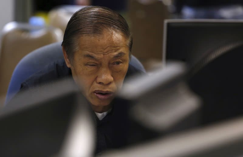 An investor monitors share prices during morning trading inside a brokerage at the financial Central district in Hong Kong