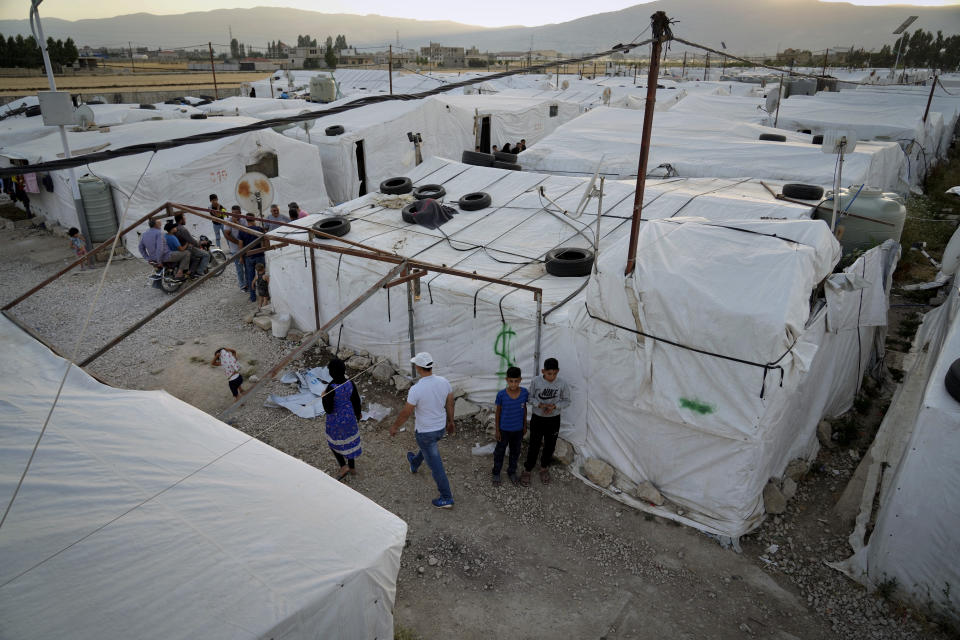 Syrian refugees walk by their tents at a refugee camp in the town of Bar Elias, in the Bekaa Valley, Lebanon, July 7, 2022. The Lebanese government’s plan to start deporting Syrian refugees has sent waves of fear through vulnerable refugee communities already struggling to survive in their host country. Many refugees say being forced to return to the war shattered country would be a death sentence. (AP Photo/Bilal Hussein)