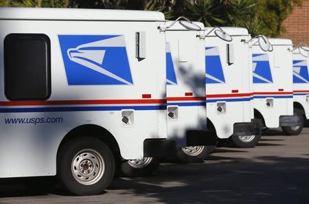 U.S. postal service trucks sit parked at the post office in Del Mar, California November 13, 2013. REUTERS/Mike Blake