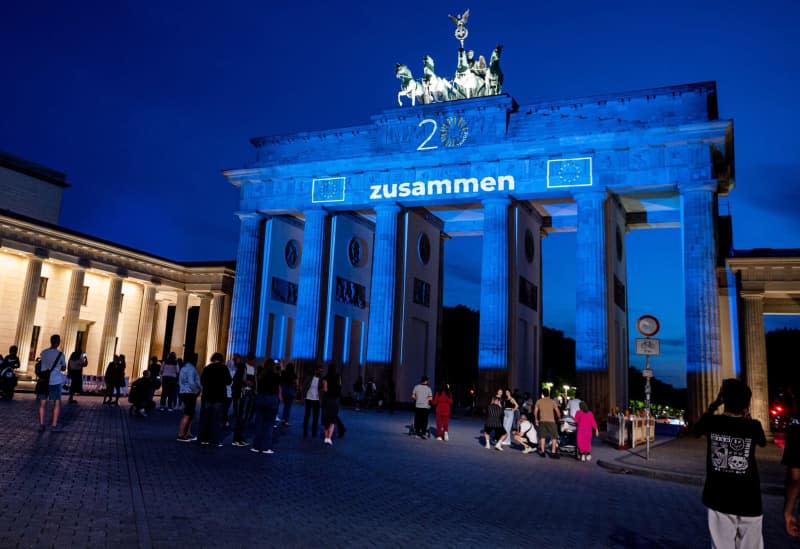 The Brandenburg Gate will be illuminated in the colors of the EU flag with the lettering "together" to mark the EU enlargement 20 years ago. Fabian Sommer/dpa