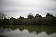 Farmers drive their tractors to join a barricade where farmers block a highway Tuesday, Jan. 30, 2024 in Jossigny, east of Paris. With protesting farmers camped out at barricades around Paris, France's government hoped to calm their anger with more concessions Tuesday to their complaints that growing and rearing food has become too difficult and not sufficiently lucrative. (AP Photo/Christophe Ena)