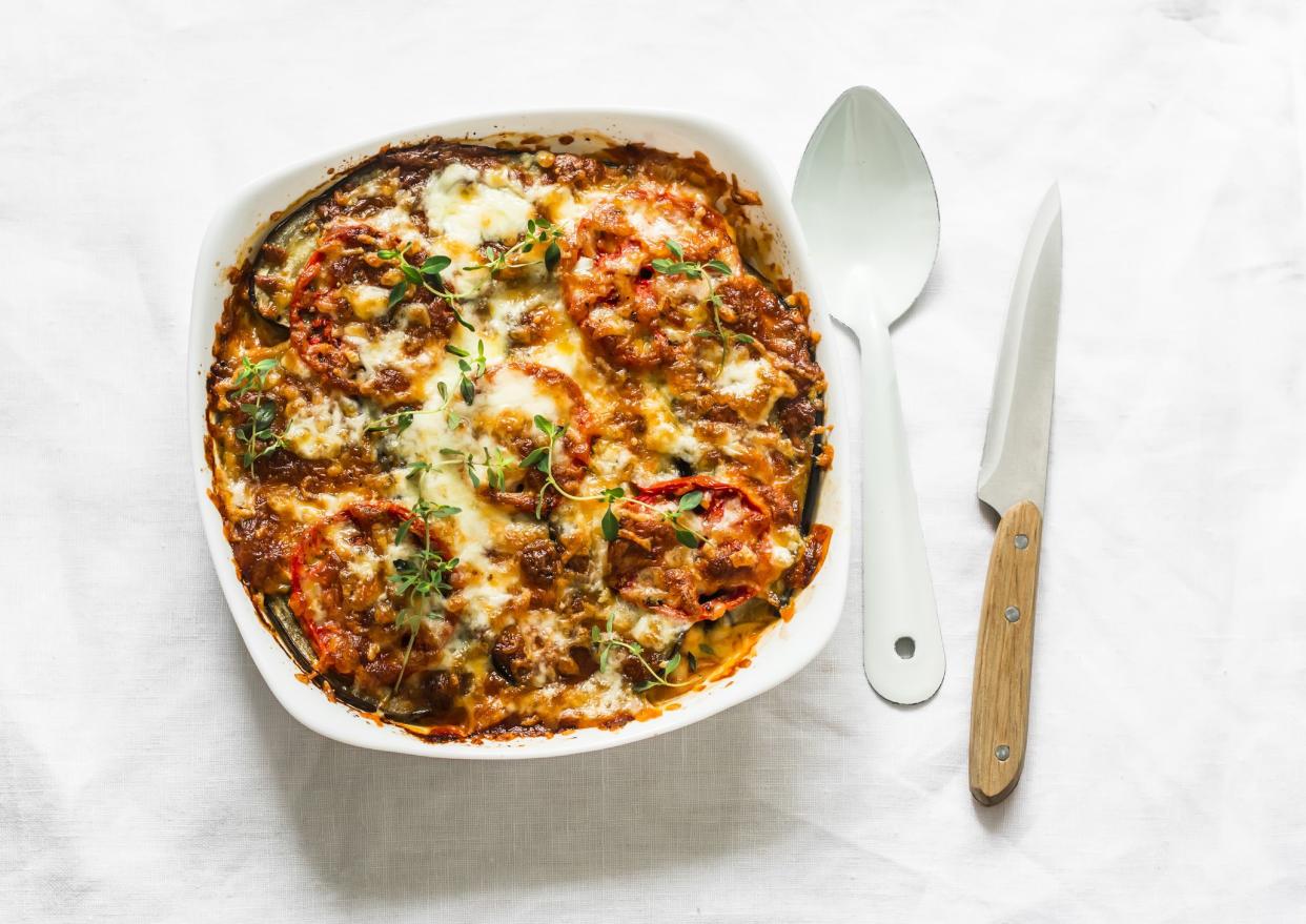 Eggplant, chicken, tomatoes, mozzarella cheese, tomato sauce casserole on a light background, top view