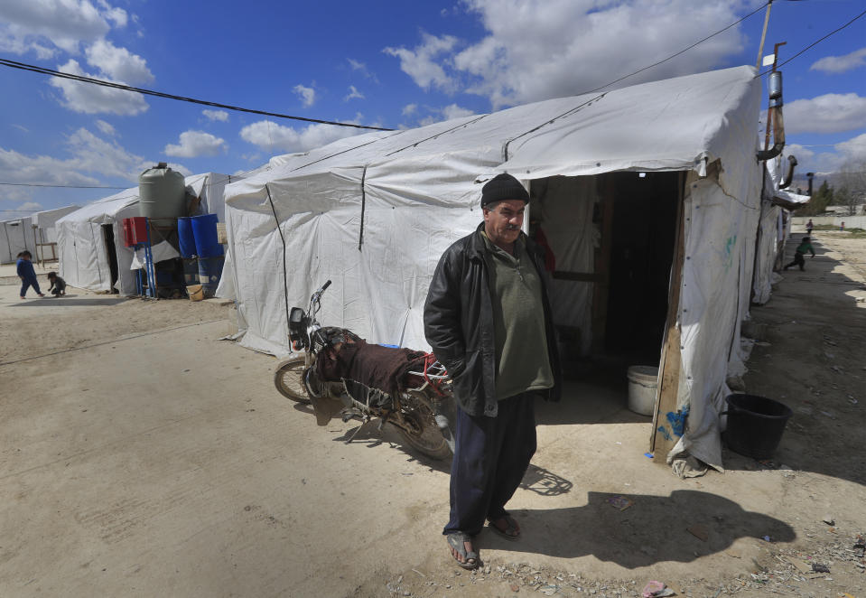 A Syrian displaced man Mohammed Zakaria, 53, who fled his Syrian hometown of Homs in 2012, stands outside his tent at a refugee camp, in Bar Elias, in eastern Lebanon's Bekaa valley, Friday, March 5, 2021. Nearly ten years later, the family still hasn't gone back and Zakaria is among millions of Syrians unlikely to return in the foreseeable future, even as they face deteriorating living conditions abroad. The Syrian conflict has resulted in the largest displacement crisis since World War II. (AP Photo/Hussein Malla)