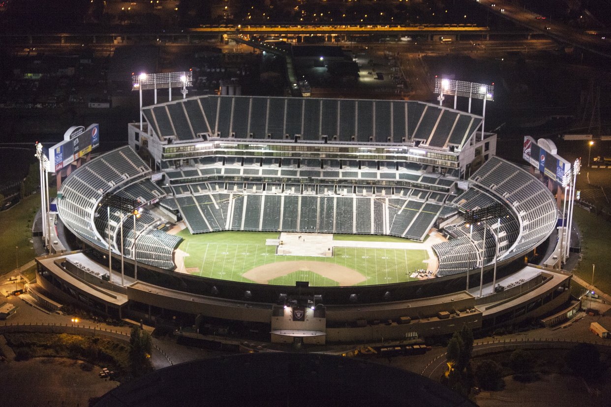 Aerial of empty, lit up inside RingCentral Coliseum, Oakland, California, home of the Oakland Athletics during night