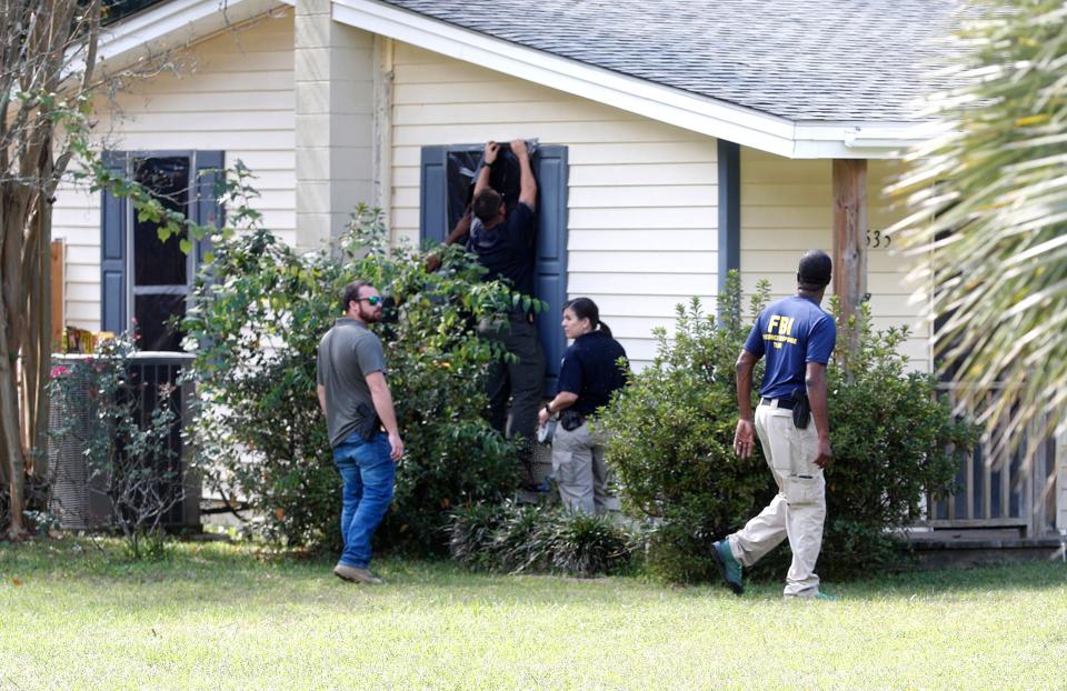 Investigators from the F.B.I. tape dark plastic over the windows of the Buckhalter Road home where Quinton Simon was last seen on the morning of October 5, 2022.