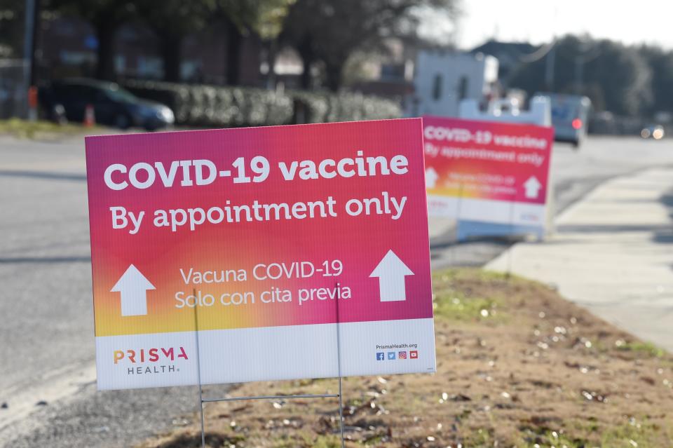 Signs line the pathway to a COVID-19 vaccine site operated by PRISMA Health in Columbia, S.C., on Tuesday, Feb. 9, 2021. (AP Photo/Meg Kinnard)