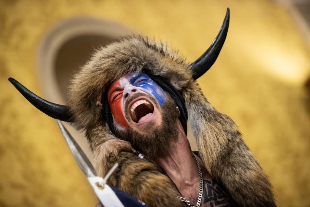 Jacob Chansley, also known as the "QAnon Shaman," screams "Freedom" inside the U.S. Senate chamber after the U.S. Capitol was breached by a mob during a joint session of Congress on January 6, 2021. (Photo by Win McNamee/Getty Images)