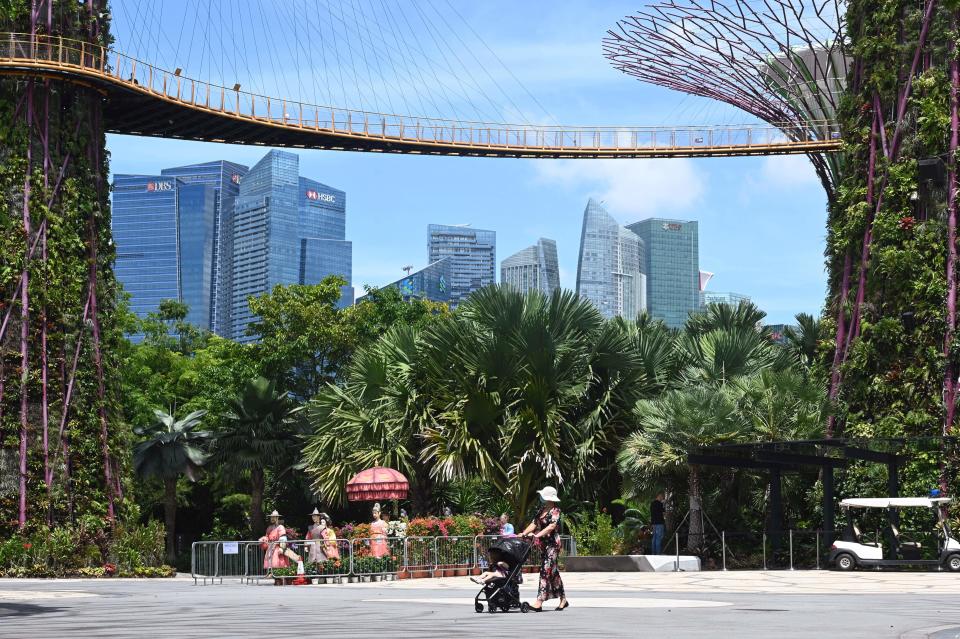 A woman pushes a baby stroller below Supertree Grove skyway at Gardens by the Bay in Singapore on September 9, 2020, after the popular tourist attraction was reopened to the public on September 7 following closures due to restrictions to halt the spread of the COVID-19 coronavirus. (Photo by ROSLAN RAHMAN / AFP) (Photo by ROSLAN RAHMAN/AFP via Getty Images)