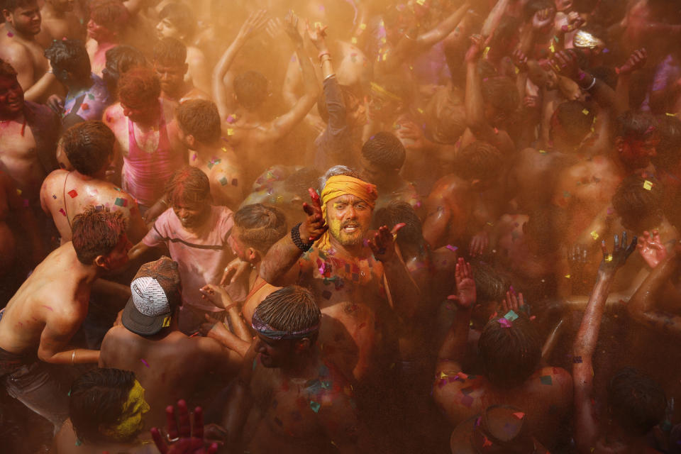 Indian revelers, faces smeared with colored powder, dance during celebrations to mark Holi, the Hindu festival of colors in Prayagraj, India, Wednesday, March 11, 2020. This exuberant festival originally held to celebrate the fertility of the land, is also associated with the immortal love of Hindu God Krishna and Radha. (AP Photo/Rajesh Kumar Singh)