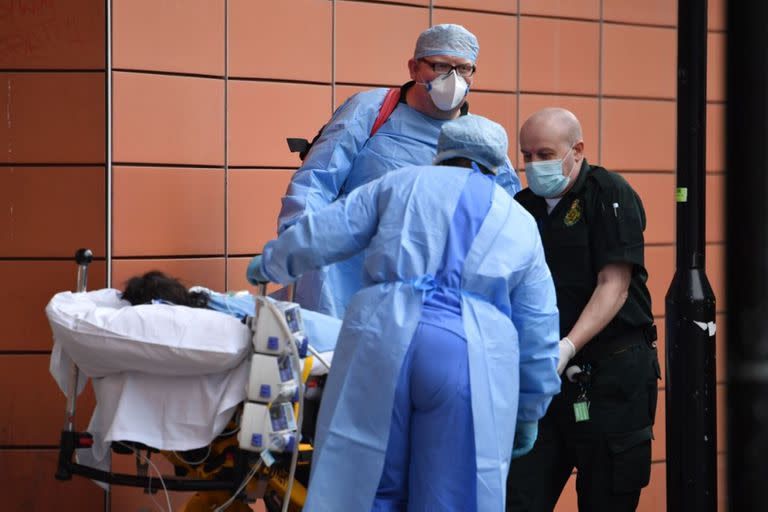 Los paramédicos descargan a un paciente de una ambulancia frente al Royal London Hospital en el este de Londres