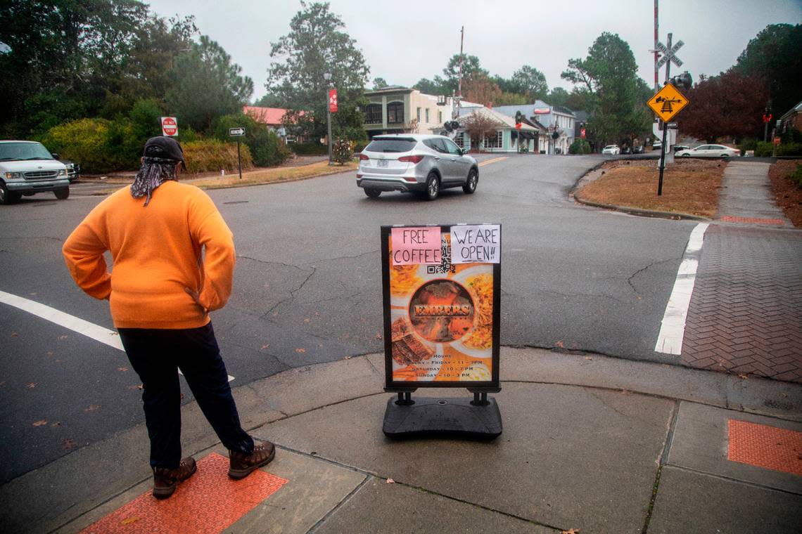 A sign advertises free coffee Wednesday, Dec. 7, 2022 as businesses began to open their doors after power was restored in downtown Southern Pines. Two deliberate attacks on electrical substations in Moore County Saturday evening caused days-long power outages for tens of thousands of customers. 
